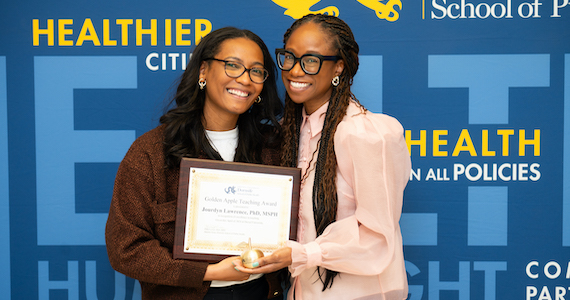 2024 Golden Apple Faculty Teaching Award Winner Jourdyn A. Lawrence, PhD, MSPH, Assistant Professor, Epidemiology, with Loni Philip Tabb, PhD, Associate Dean for Faculty Affairs and Associate Professor of Biostatistics